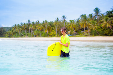 Surfer on tropical beach. Boy surfing.