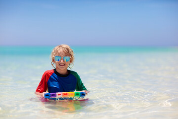 Kids surf on tropical beach. Vacation with child.