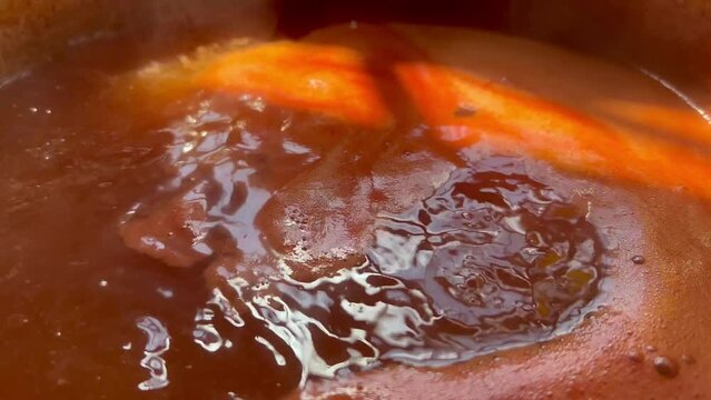 Cooking tomato sauce from fresh tomatoes in a pot