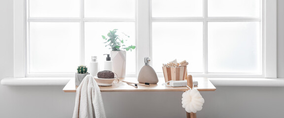 Body care cosmetics and accessories on table in light bathroom