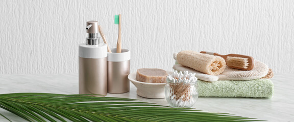 Natural bath accessories on table in light bathroom