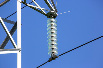High voltage tower with electrical voltage wires isolates close-up against the background of...