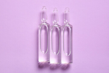 Medical ampules on lilac background