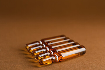 Glass ampules on brown background