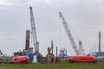 Cranes, lifeboats, life rafts, at an old deserted port in Luisiana