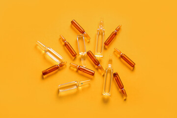 Glass medical ampules on yellow background