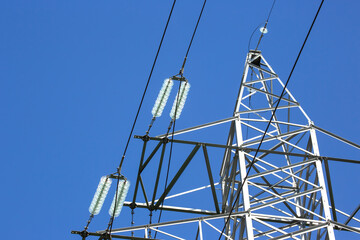 High voltage tower with electrical voltage wires isolates close-up against the background of...
