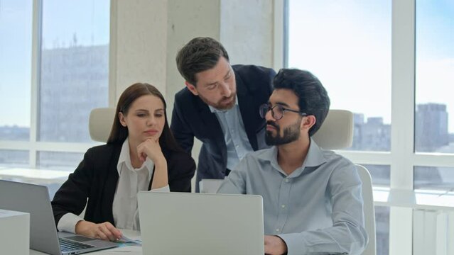 Mentor help colleagues with corporate work on laptop businessman teaching businesswoman analyze online project result discuss business development supervisor teach multiracial team managers at office
