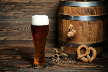 Glass of cold beer and barrel on wooden background. Oktoberfest celebration