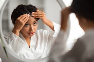 Worried Young Black Woman Checking Her Hair Roots At Home - Powered by Adobe