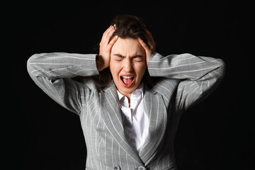 Young woman having panic attack on dark background