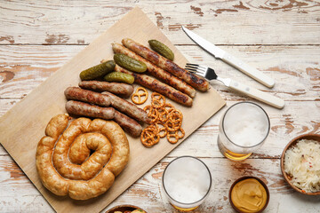 Glasses of cold beer and different snacks on light wooden background. Oktoberfest celebration