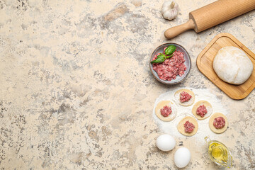 Raw dough with minced meat and ingredients for preparing dumplings on beige background