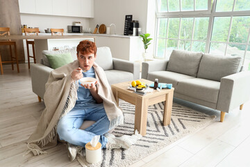 Fototapeta premium Ill young man eating soup at home