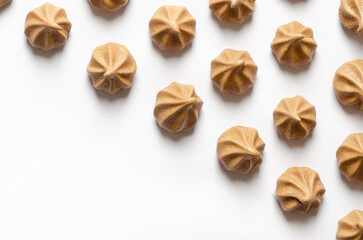 Mini chocolate meringue cookies on white background.