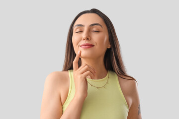 Young woman gesturing on light background, closeup