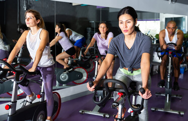 Woman ride stationary bike in a fitness club