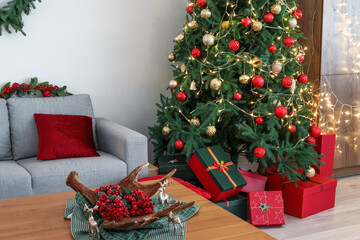 Interior of living room with Christmas tree, gift boxes, grey sofa and coffee table
