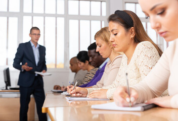 Fototapeta premium Portrait of confident woman sitting in class working during group business training