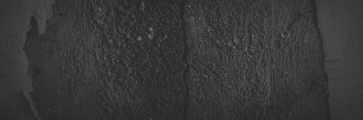 Dark panoramic background for design. Torn old faded paper wallpaper with a retro pattern. Ragged scraps of paper on a concrete wall. Shaded vintage tattered paper texture. Wide panorama with vignette