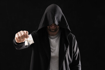 Male junkie with drugs on black background