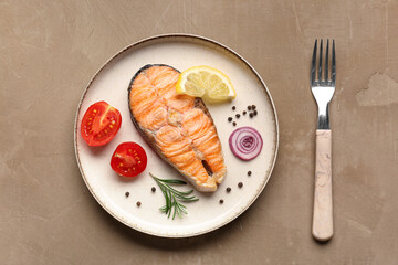 Plate with tasty grilled salmon steak on beige background