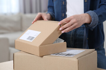 Woman unpacking parcel at home, closeup. Online store