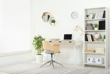 Beautiful workplace with comfortable desk and chair at home