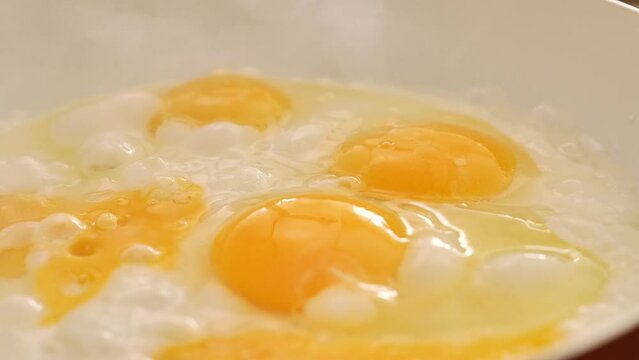 Fried eggs for breakfast. protein breakfast. bubbling scrambled eggs.Appetizing fried eggs in sunflower oil. process of preparing breakfast. Frying pan with eggs in the morning sunlight