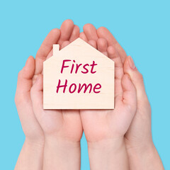 First time home buyer. Woman with her little child holding house figure on light blue background, top view