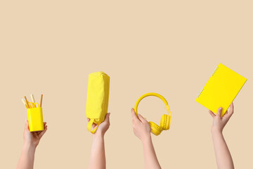 Female hands holding school supplies on beige background