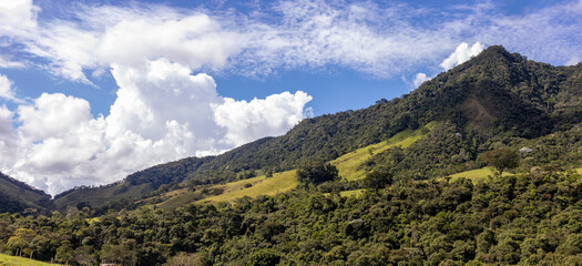 Panorama of mountainous terrain with forest and small houses. Panoramic view of vast expanses of mountain ranges and large ranges on the horizon. Immense distances of wavy relief. Rio de Janeiro