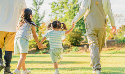 秋のキャンプ場で遊ぶ家族・ファミリーの後ろ姿（アウトドア・旅行・レジャー・ピクニック）

