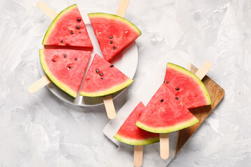 Plate and board with sweet watermelon sticks on grunge background