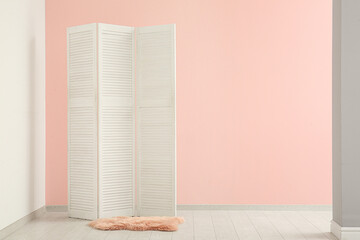 Folding screen and carpet near pink wall