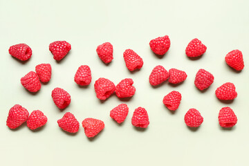 Many fresh raspberries on light green background