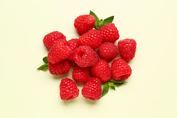 Heap of fresh raspberries and mint on light background
