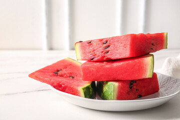 Plate with pieces of fresh watermelon on white table