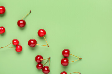 Obraz na płótnie Canvas Red sweet cherries on green background