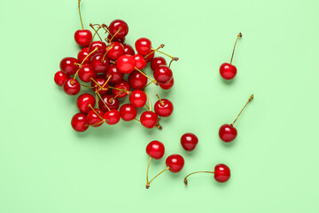 Obraz na płótnie Canvas Heap of red sweet cherries on green background