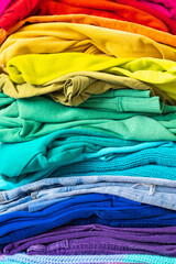 A stack of clothes in different colors. The concept of conscious clothing consumption.