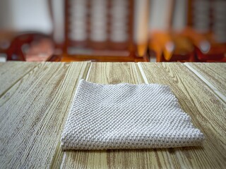 Cloth on the wooden empty table in front of blurred background. Space and landscape.
