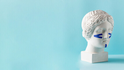 Blue tapes for the face on the bust on a blue background. Non-surgical facelift, rejuvenation.