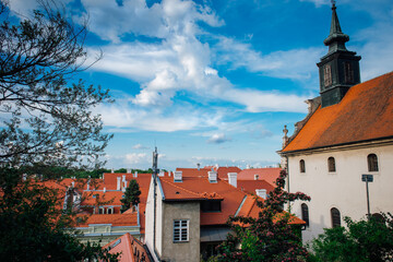 Obraz premium Petrovaradin, Serbia - May 09, 2023. Petrovaradin is historic town on right bank of Danube in Serbia, part of Novi Sad. Top view of the tiled orange roofs with white chimneys and magic cloudy sky