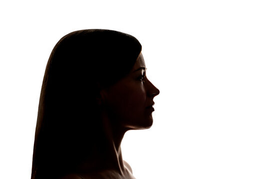 Dark silhouette of a young woman on white background side view, the concept of anonymity.
