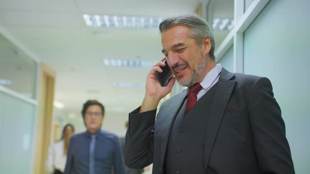 Caucasian businessman talk on phone and walking in corridor of office. 