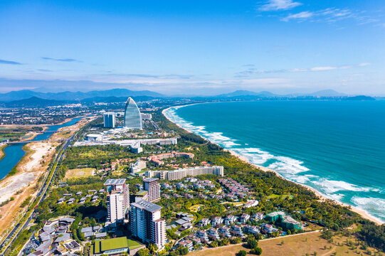 Aerial shots of the waves, coconut groves and cityscape along the coastline of Haitang Bay in Sanya