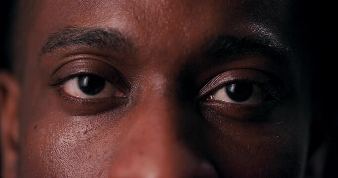 Captivating stare of an African American man demands attention in a striking close-up shot, hinting at the depth and complexity of his thoughts and emotions.