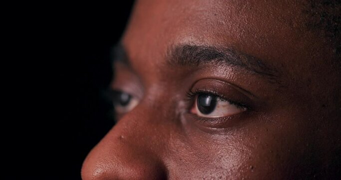 Piercing eyes gaze unflinchingly from a close-up shot of an African American man's face, conveying a sense of strength, resilience, and determination.