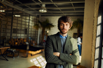 Portrait of a young man looking at the camera while working in a startup company